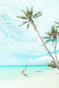 Illustration of a travel blogger planning an affiliate strategy on a laptop with a tropical beach background.